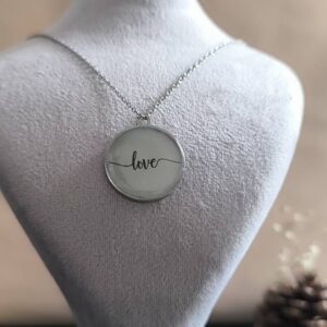 تصویر گردنبند گرد شبتاب با نوشته love که در تاریکی با نور سبز میدرخشد.