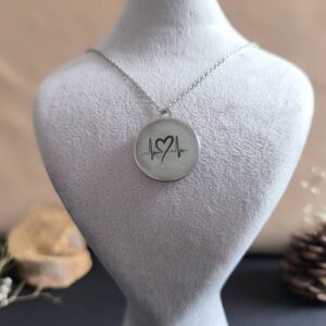 گردنبند شبتاب دایرهای با طرح ضربان قلب و قلب در حال درخشش سبز در تاریکی.